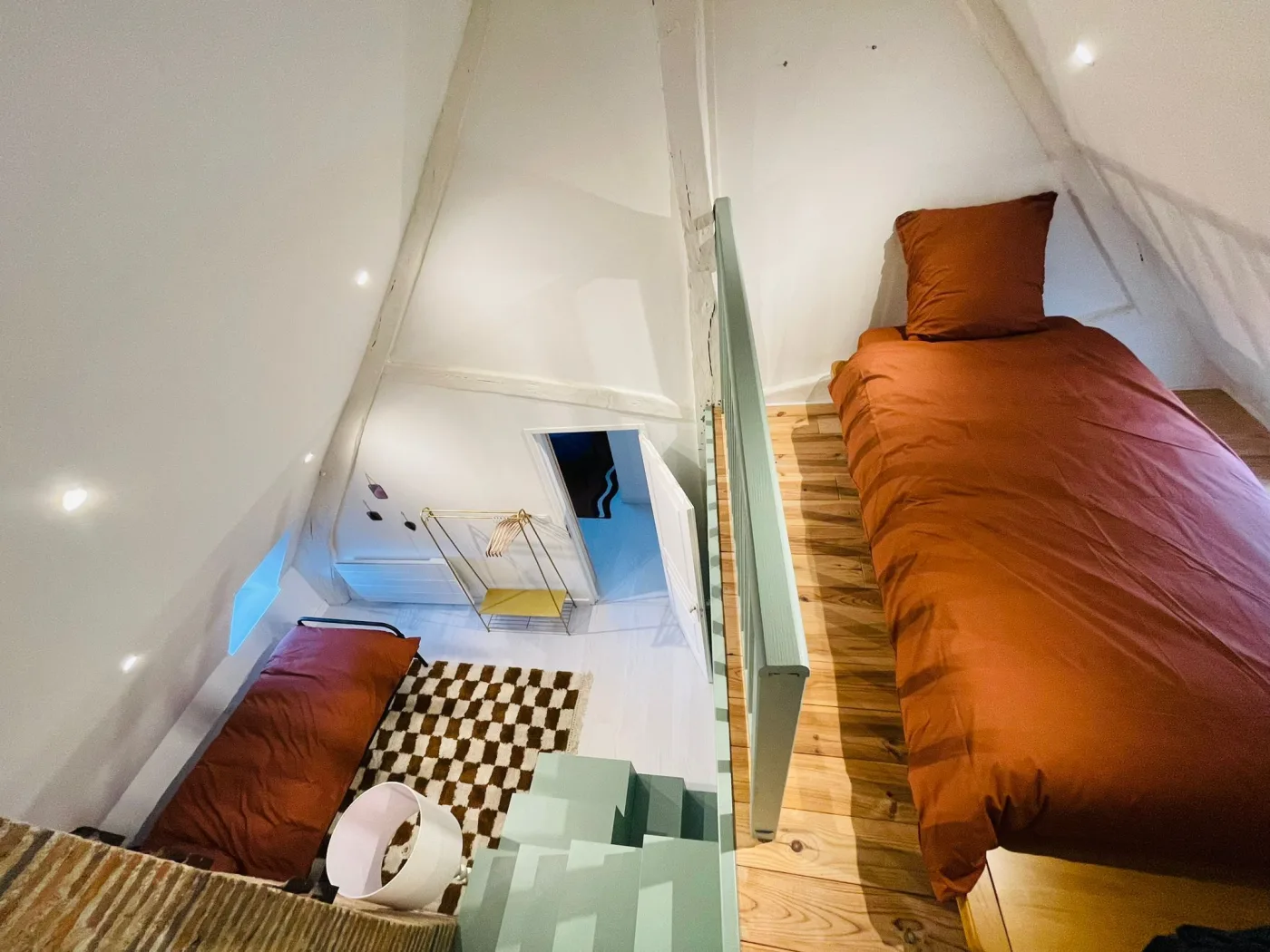 Chambre double sous les combles avec un lit en nichoir mezzanine et escalier vert
